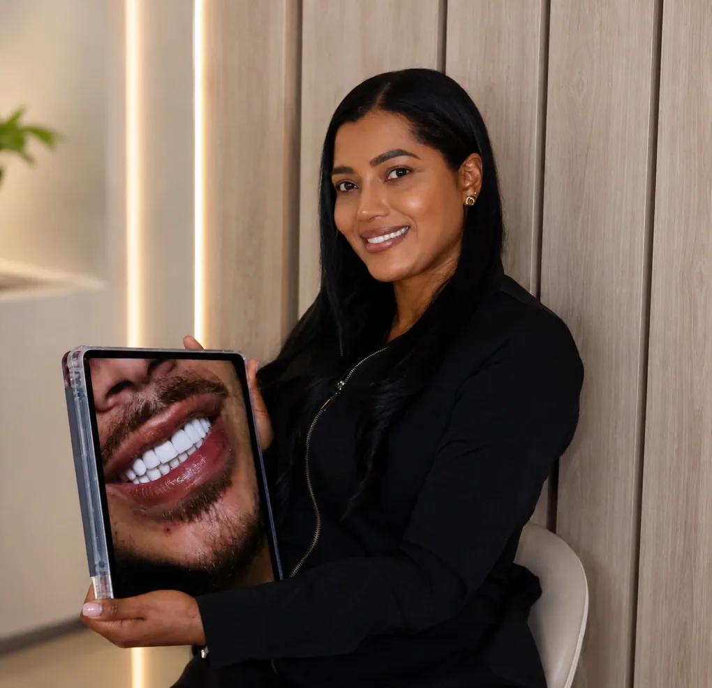 Dra. Jennifer Sinisterra holding a tablet with a dental case photo